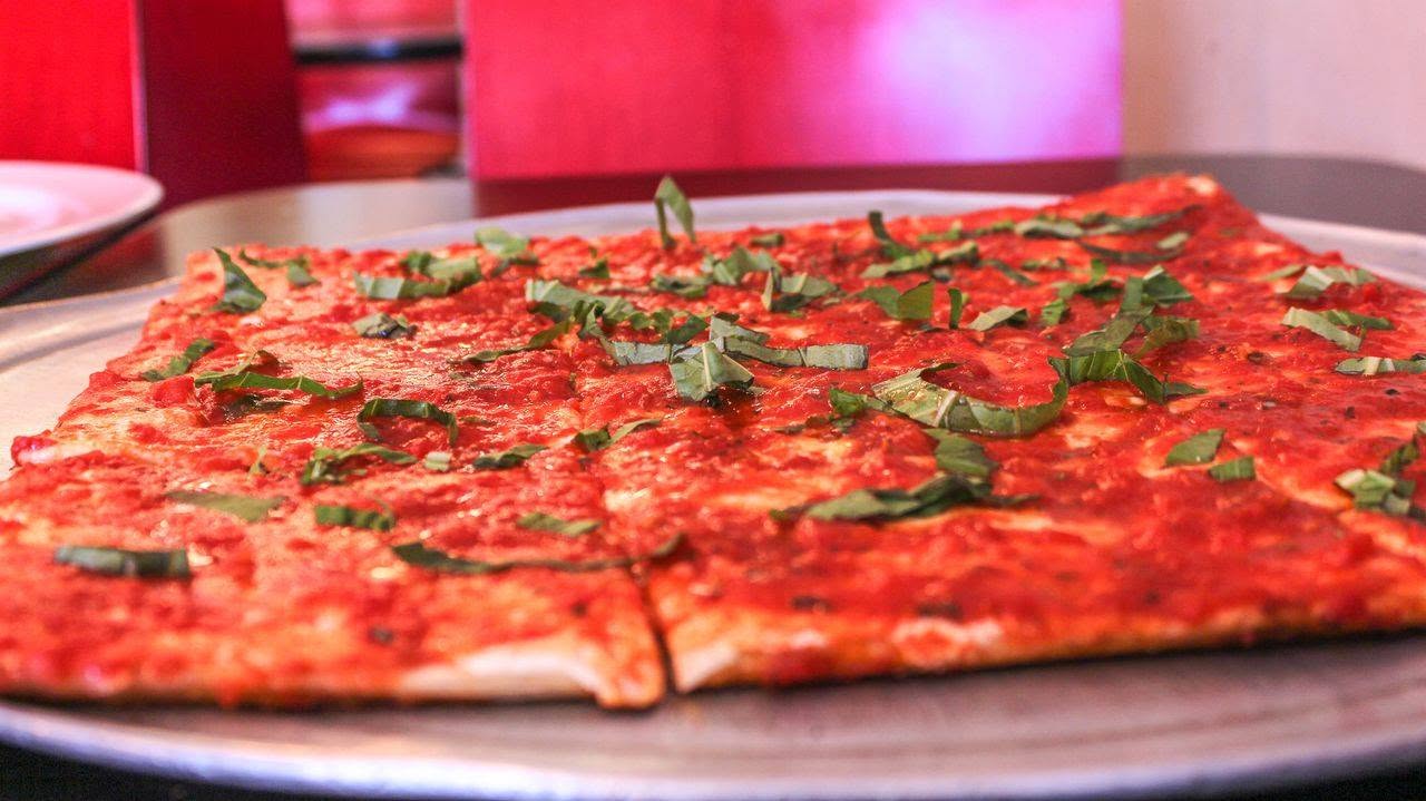 Sliced cheese pizza on a wooden board